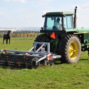 L4310 5 26 5 18 coulters xarm roller Yeomans plow L4310 5 26 5 18 coulters xarm crumble roller fitted to a john deere - plowing a green grassy field